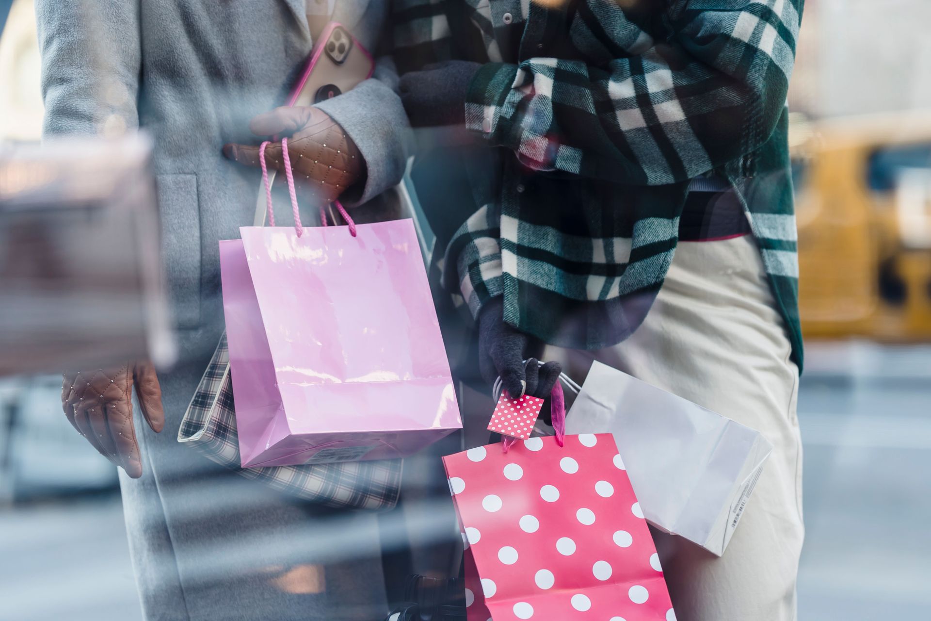 Two people holding pink shopping bags outdoors