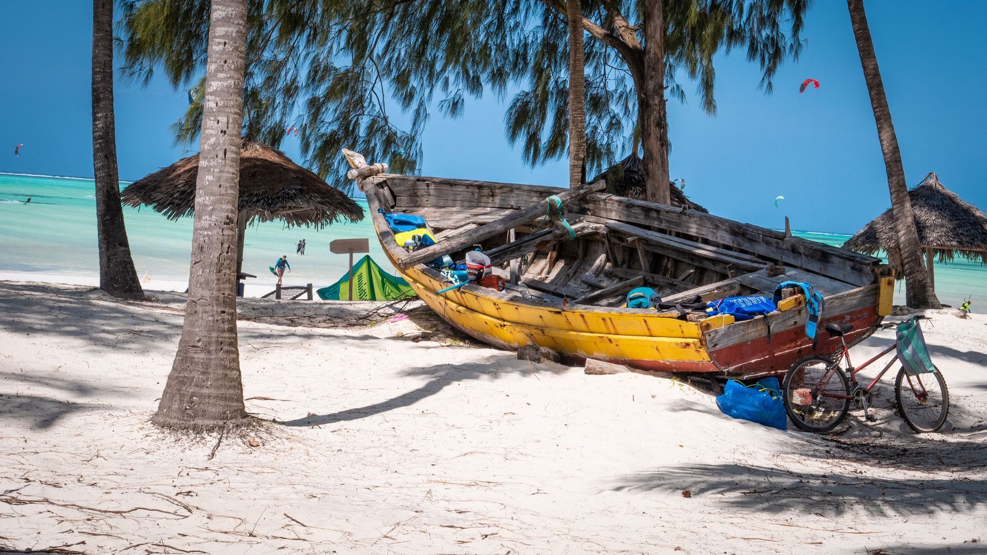 Colorful boats on a sunny tropical beach with palm trees and white sand