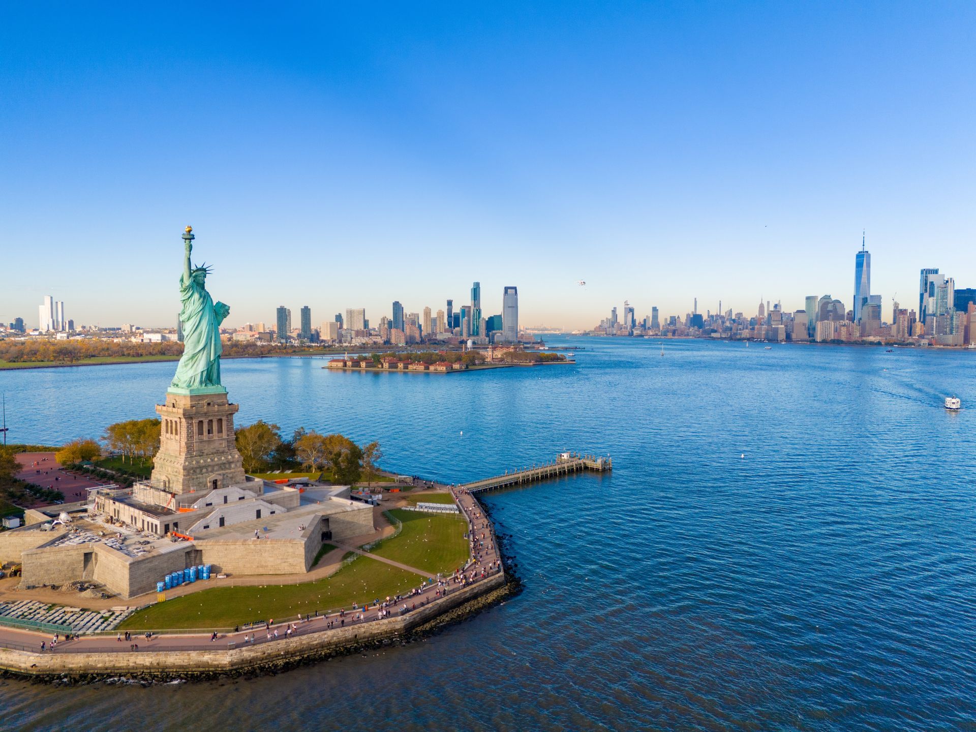 Statue of Liberty with Manhattan skyline across New York Harbor on a clear day