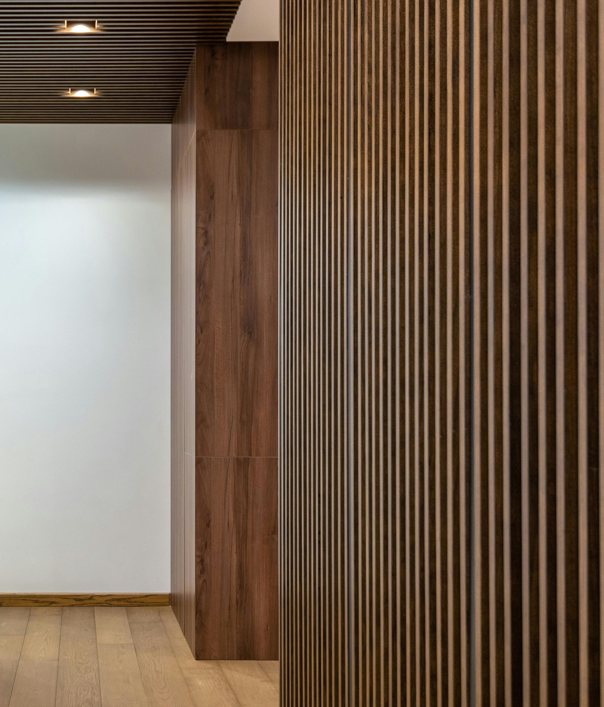 A hallway with a wooden wall and a wooden floor.