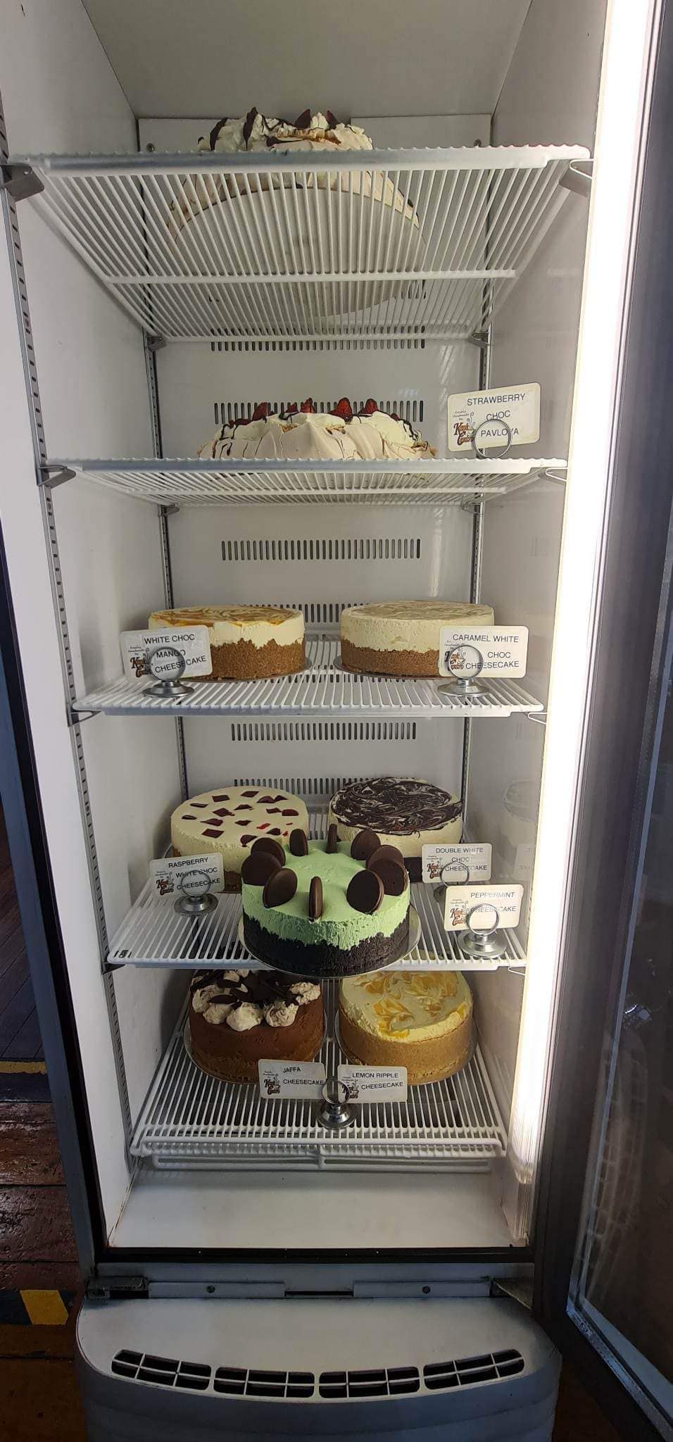 A Refrigerated Display Case Filled with Various Cakes — Kape Centro In Childers, QLD 