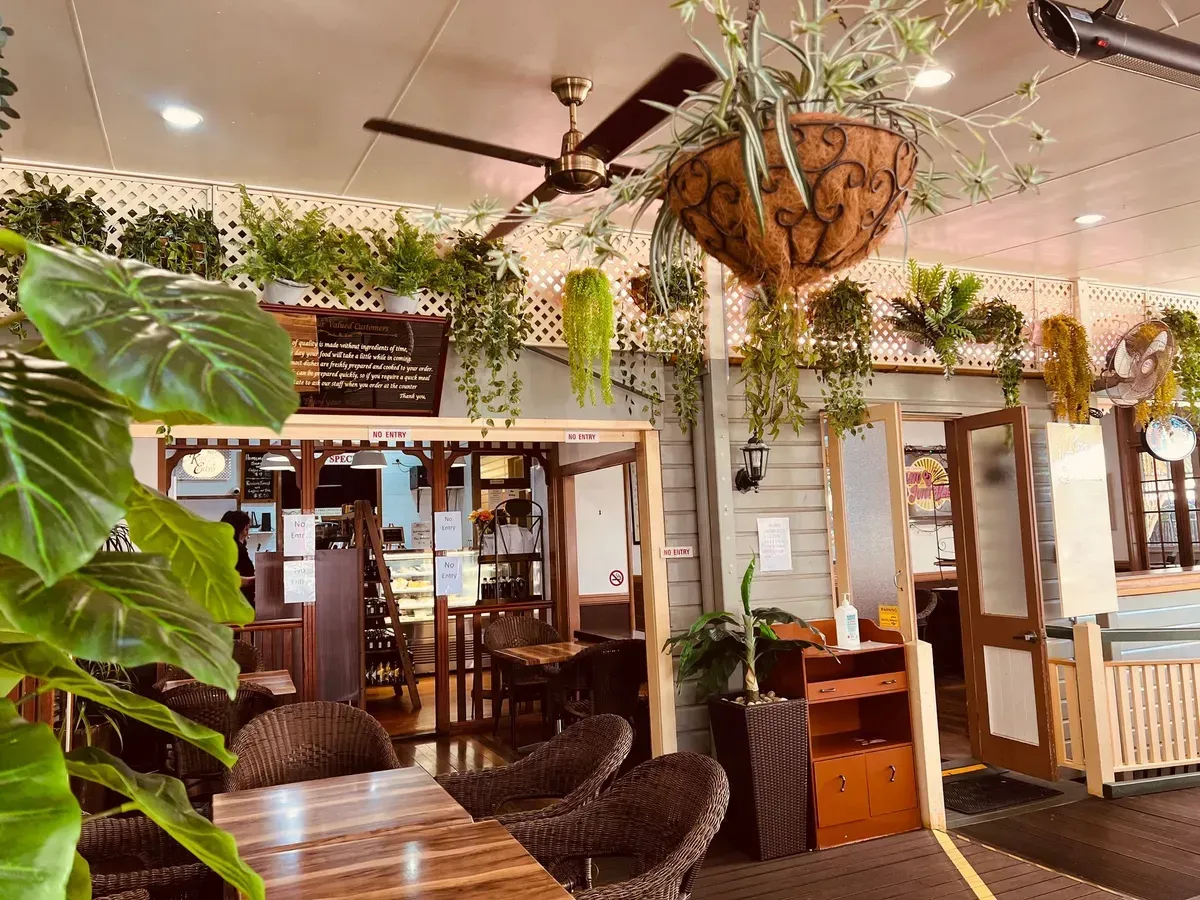 Outdoor Restaurant Seating Area with Large Wooden Tables — Kape Centro In Childers, QLD