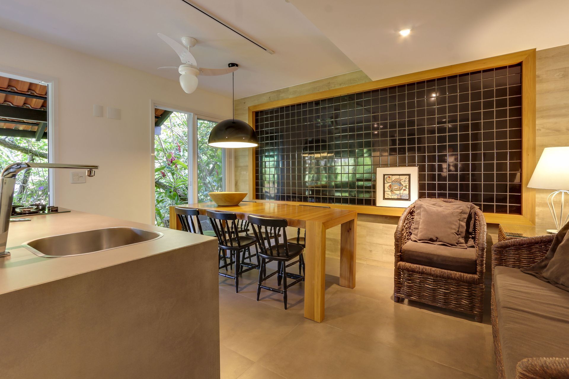 Sala de estar e jantar modernas em conceito aberto, com mesa de madeira, poltrona e janela ampla.