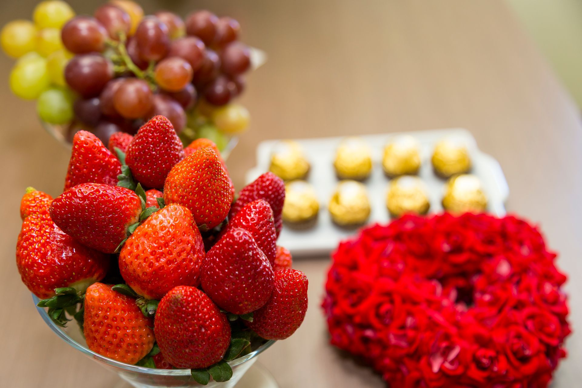 Tigelas de morangos e uvas com sobremesas variadas sobre uma mesa