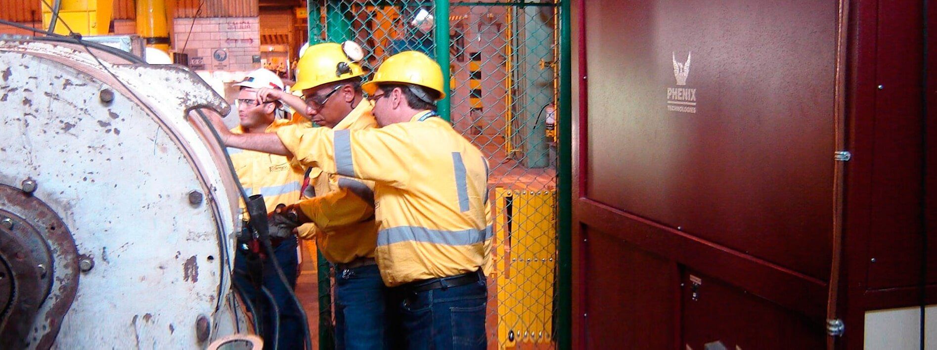 Un grupo de hombres que llevan cascos de seguridad están trabajando en una máquina.