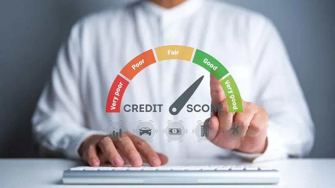 A person uses a keyboard while interacting with a digital graphic of a credit score gauge