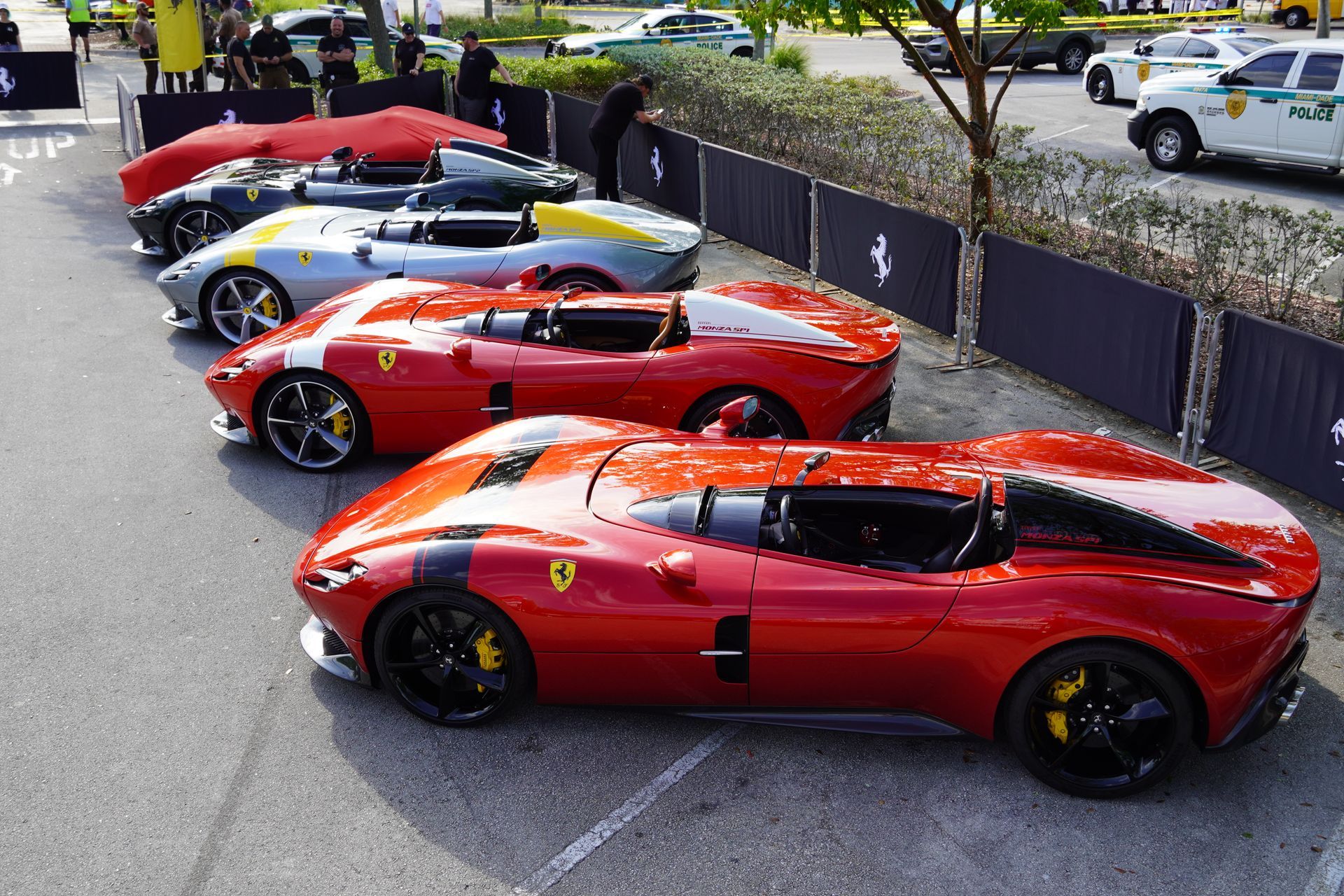 A row of red sports cars are parked in a parking lot