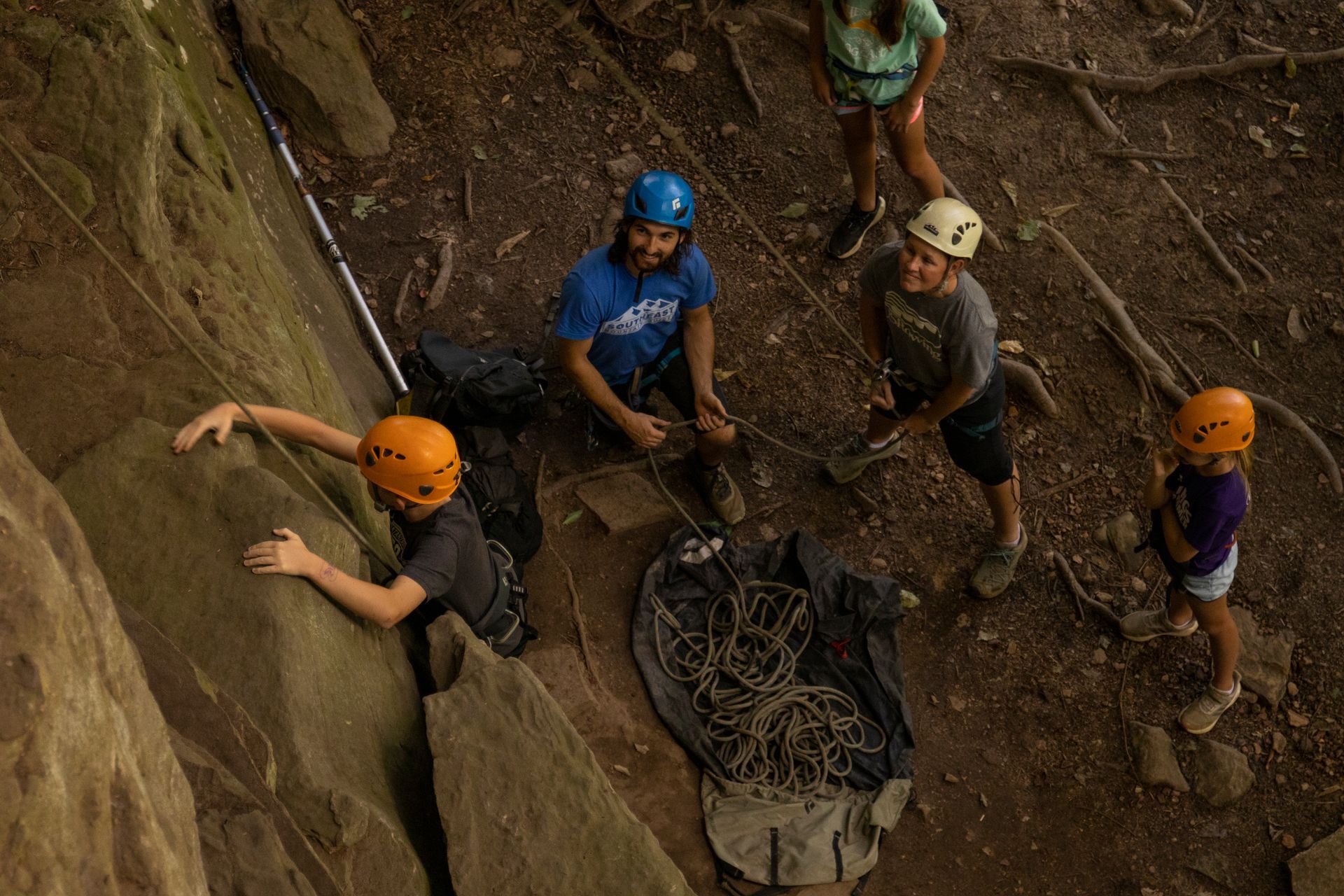 climbing guides look on as climber scales route in the red river gorge