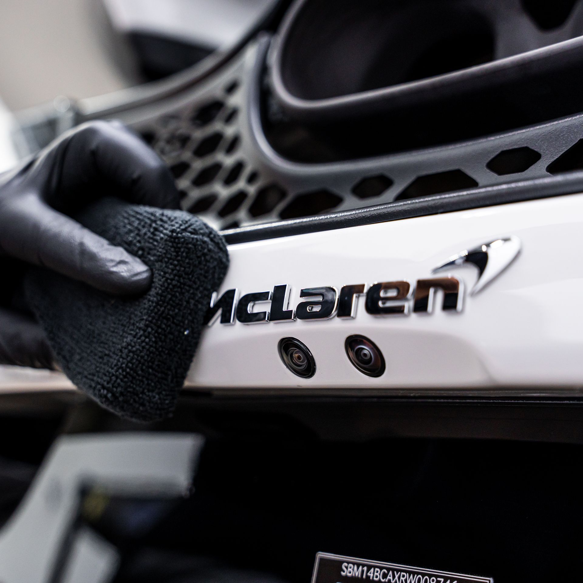 A person in black gloves wiping the chrome