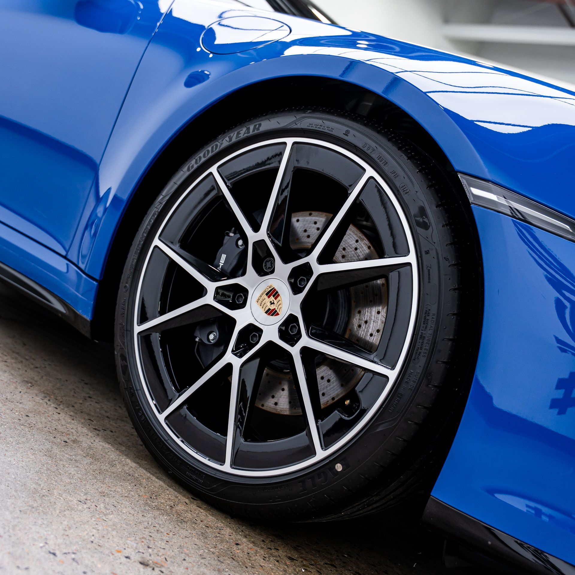 Blue Porsche car wheel with black and silver rims.