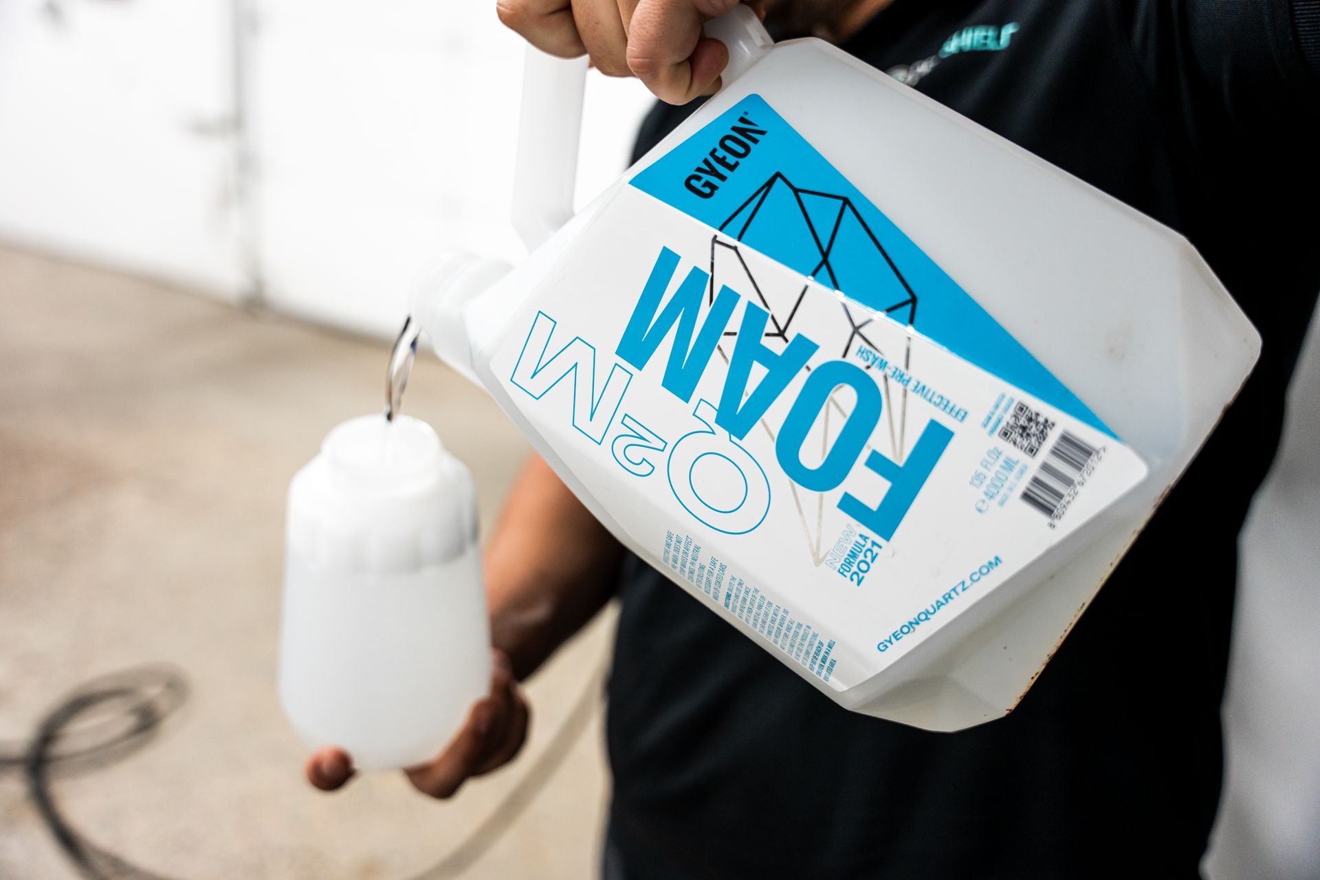 Person pouring foam from a white container labeled