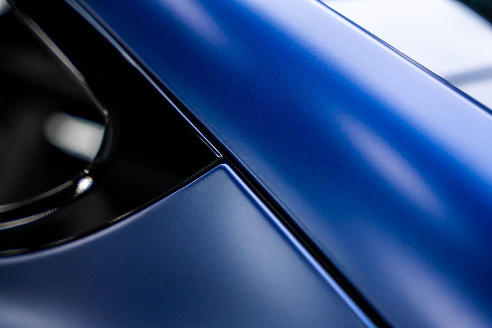A close up of a blue car with a black rim.