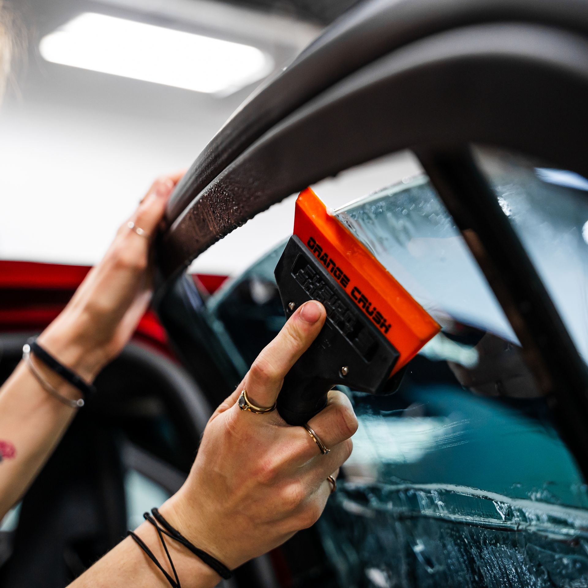 A person is holding a squeegee that says range rover on it