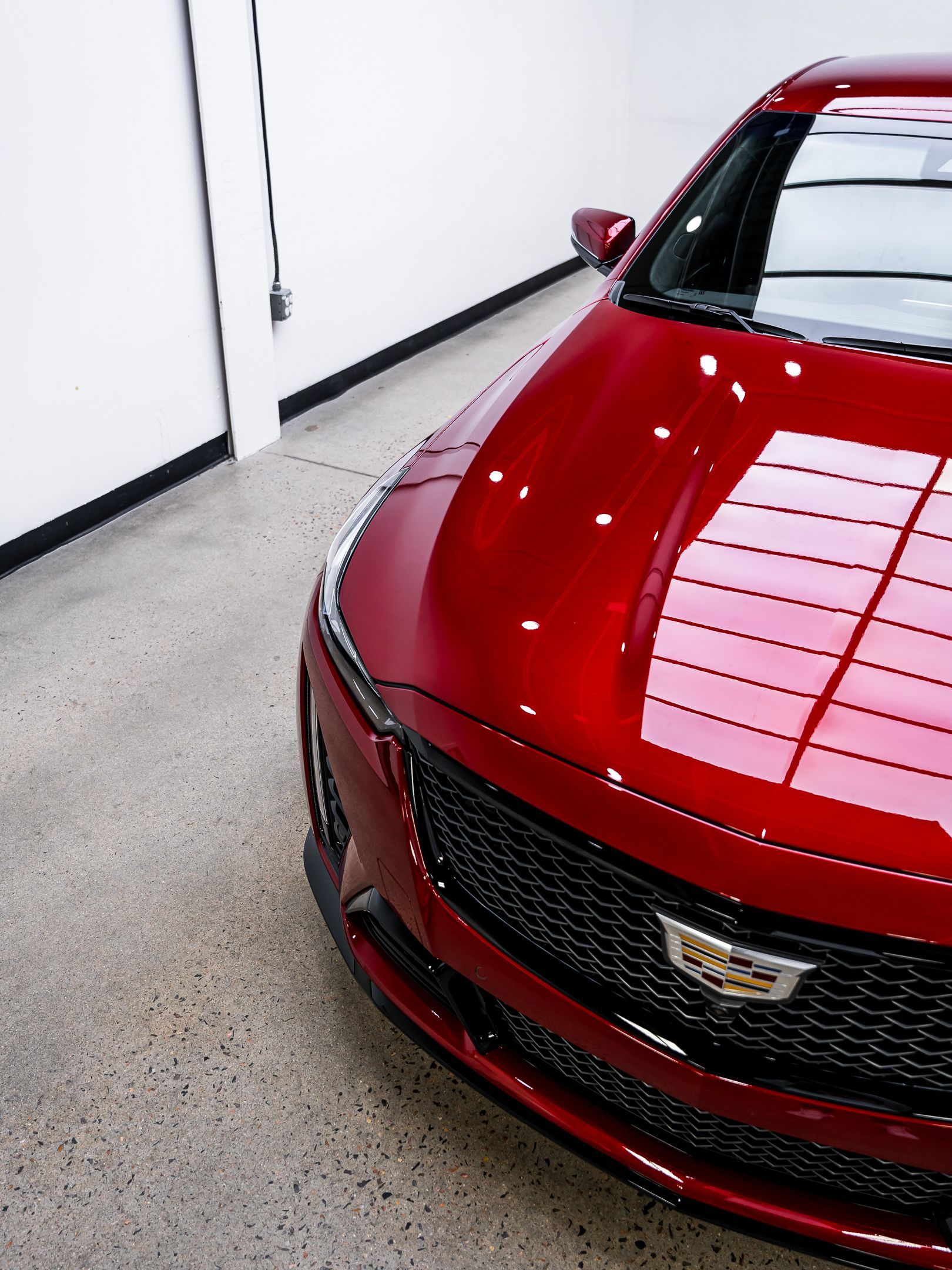 A red cadillac is parked in a garage.