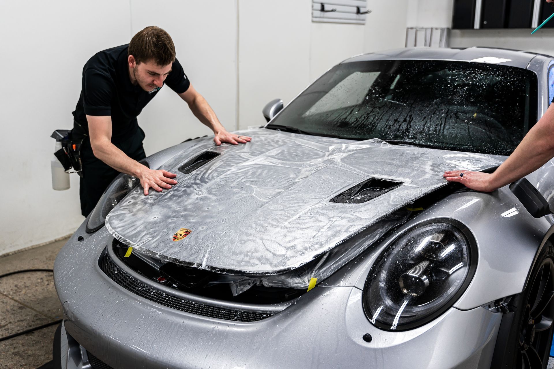 Laying paint protection film on the hood of the car