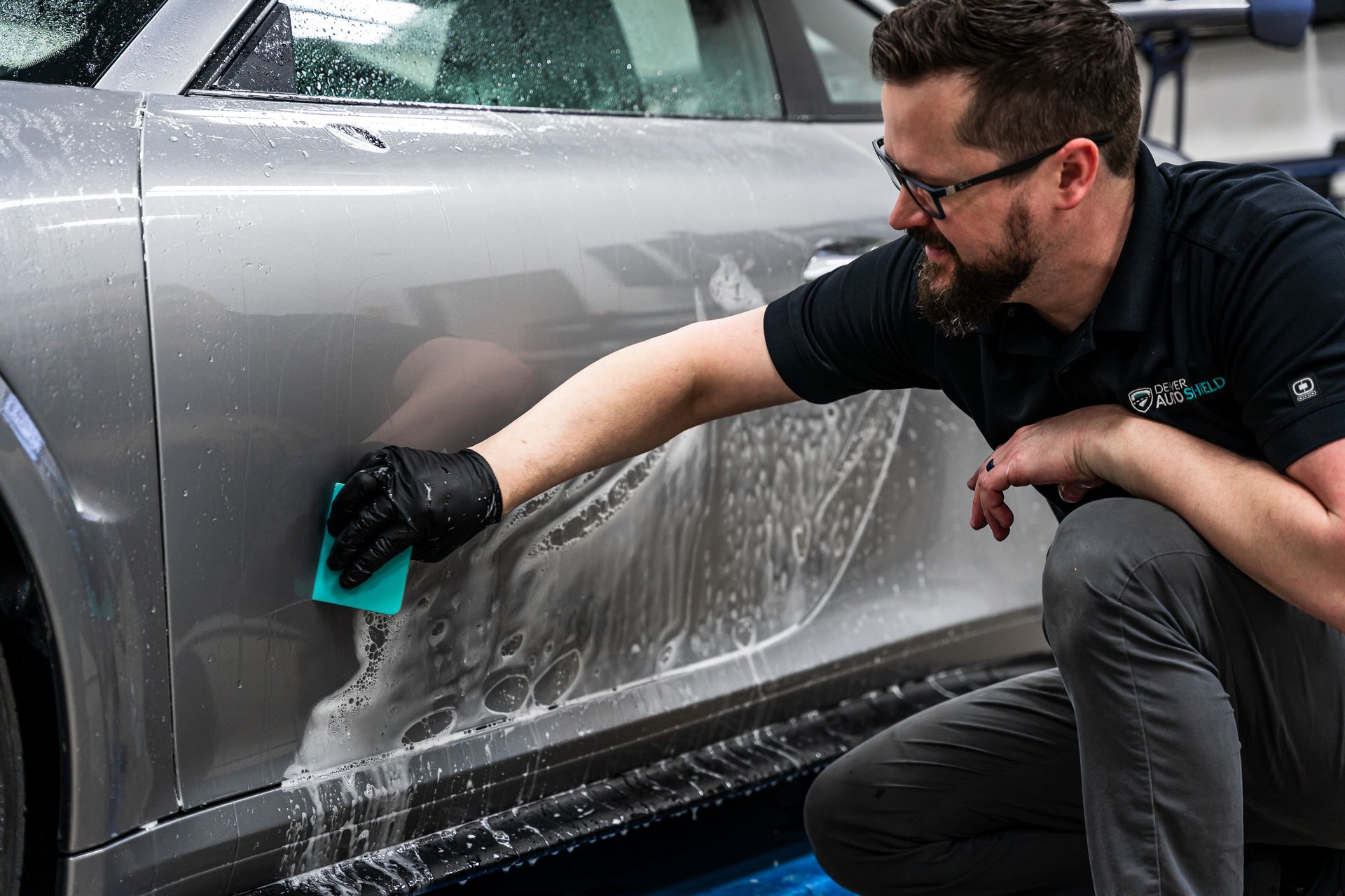 Using a squeegee to install clear bra