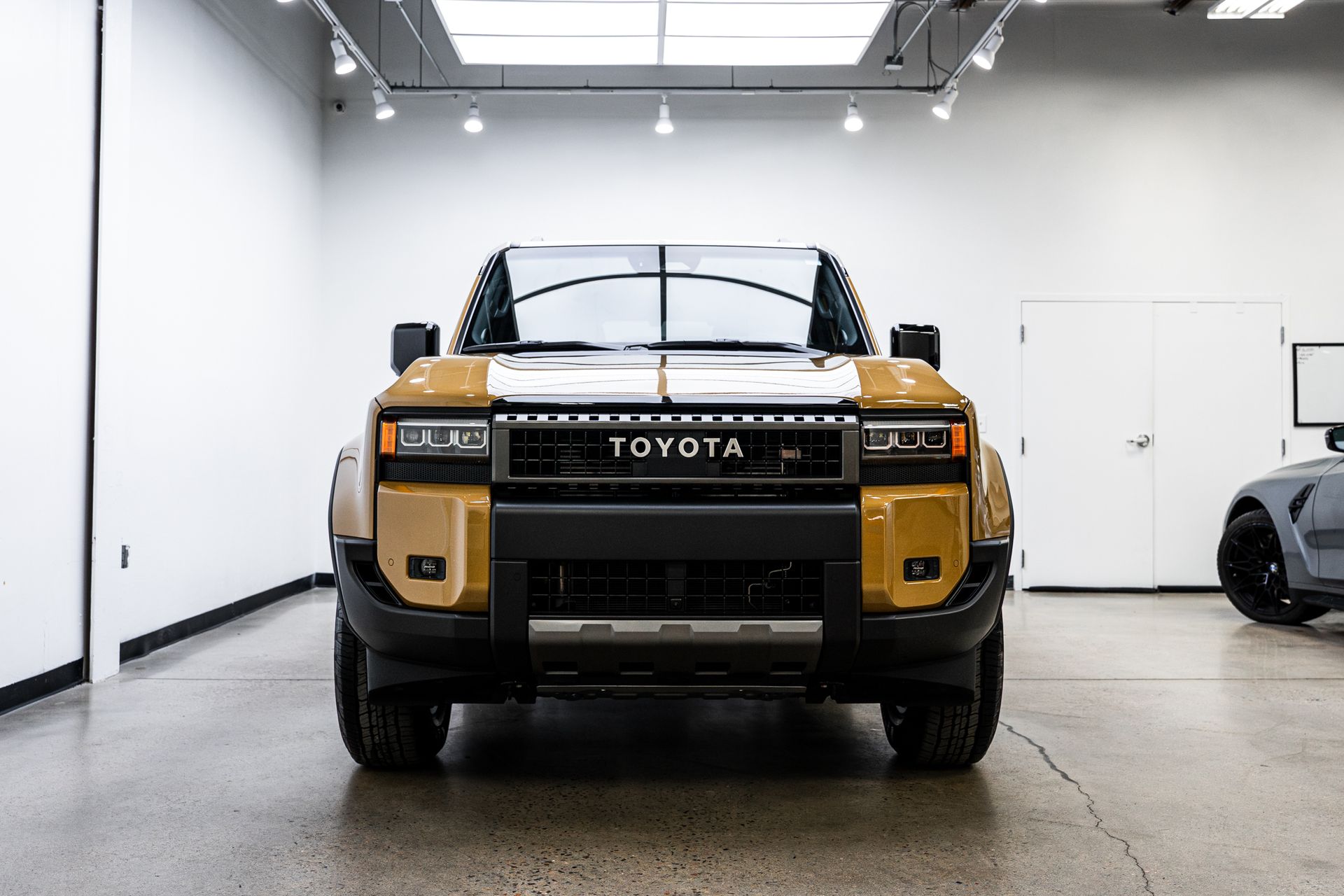 A gold and black Toyota pickup truck displayed in a showroom.