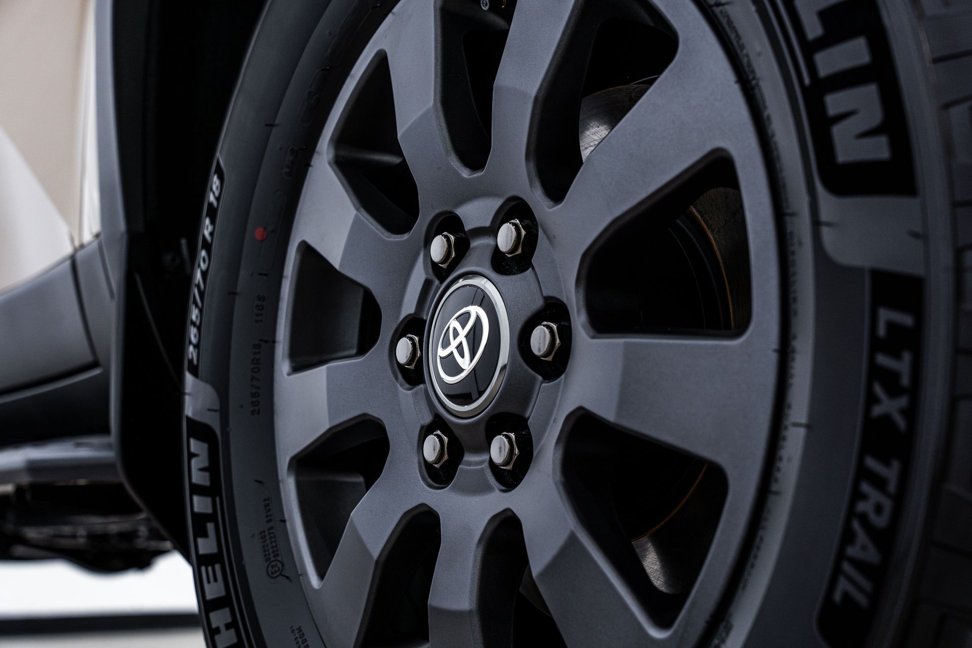Dark gray car wheel with a black Toyota emblem and a Michelin tire.