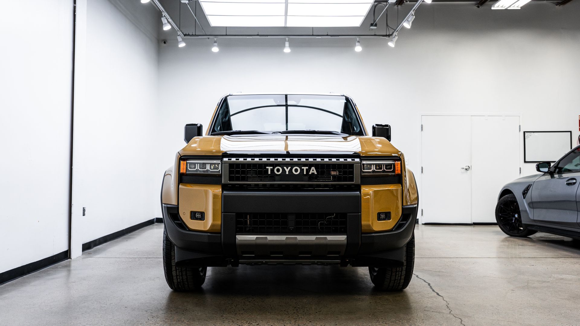 Toyota pickup truck with gold-colored front, indoors, facing forward.