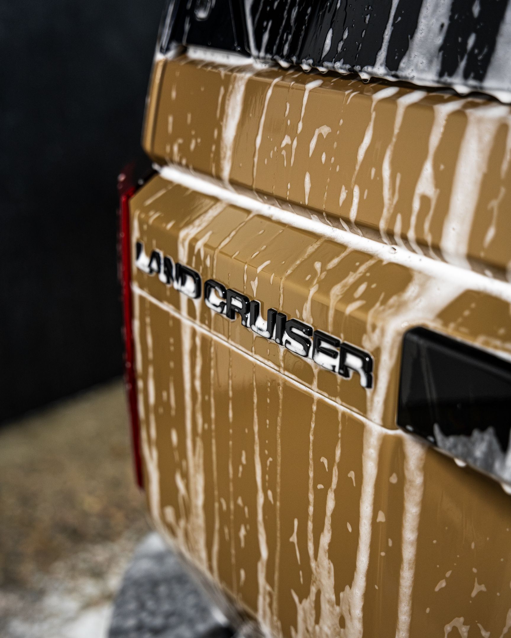 Brown Toyota Land Cruiser rear end with soap,