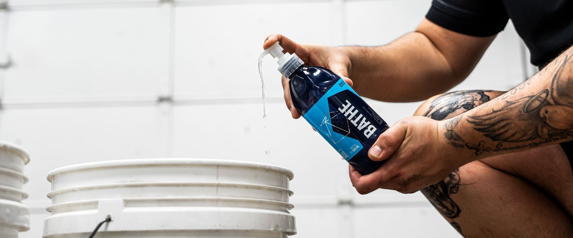 A person squirts liquid from a bottle labeled 