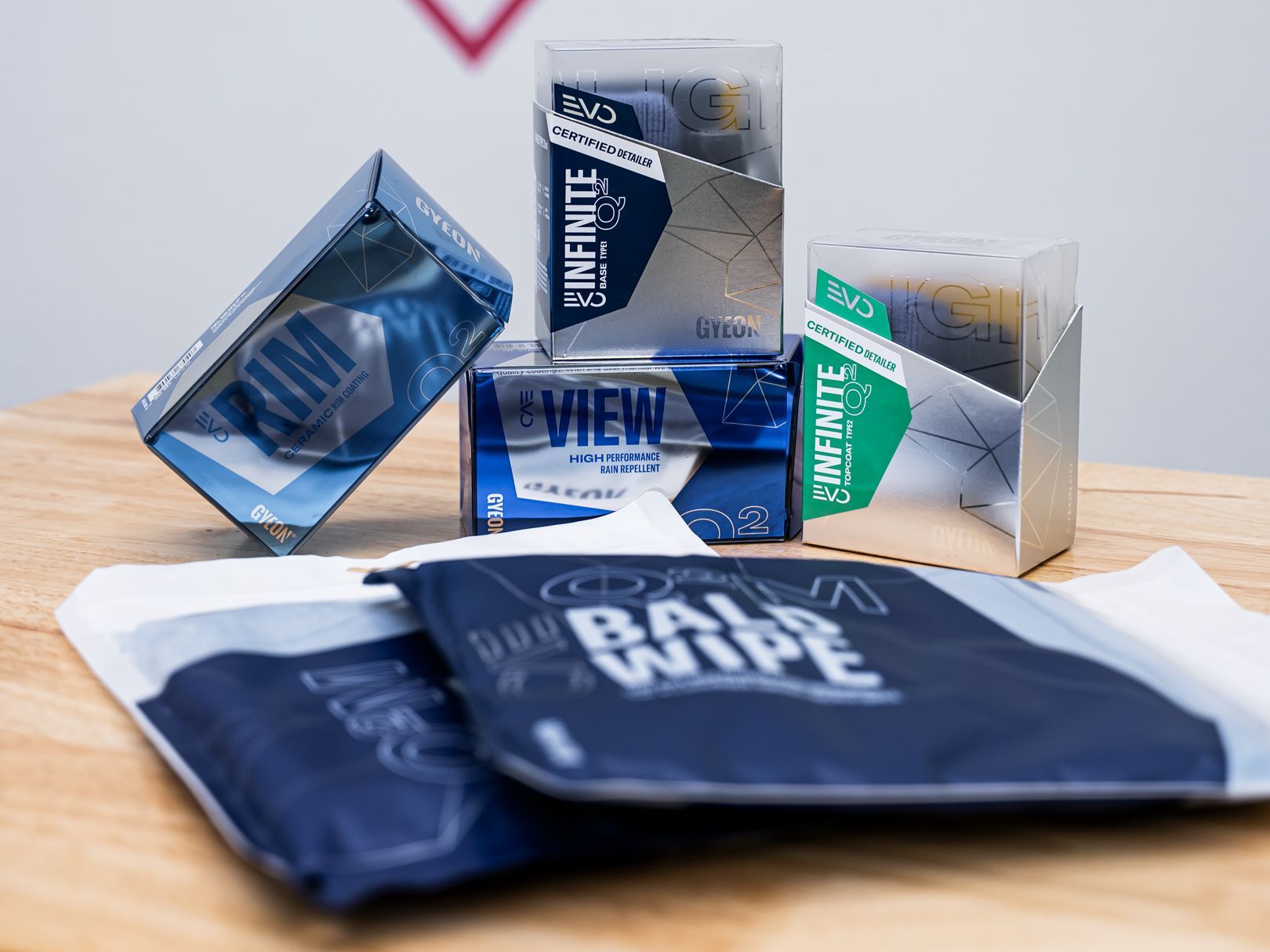 A group of automotive ceramic coating wipes sits on a wooden table.
