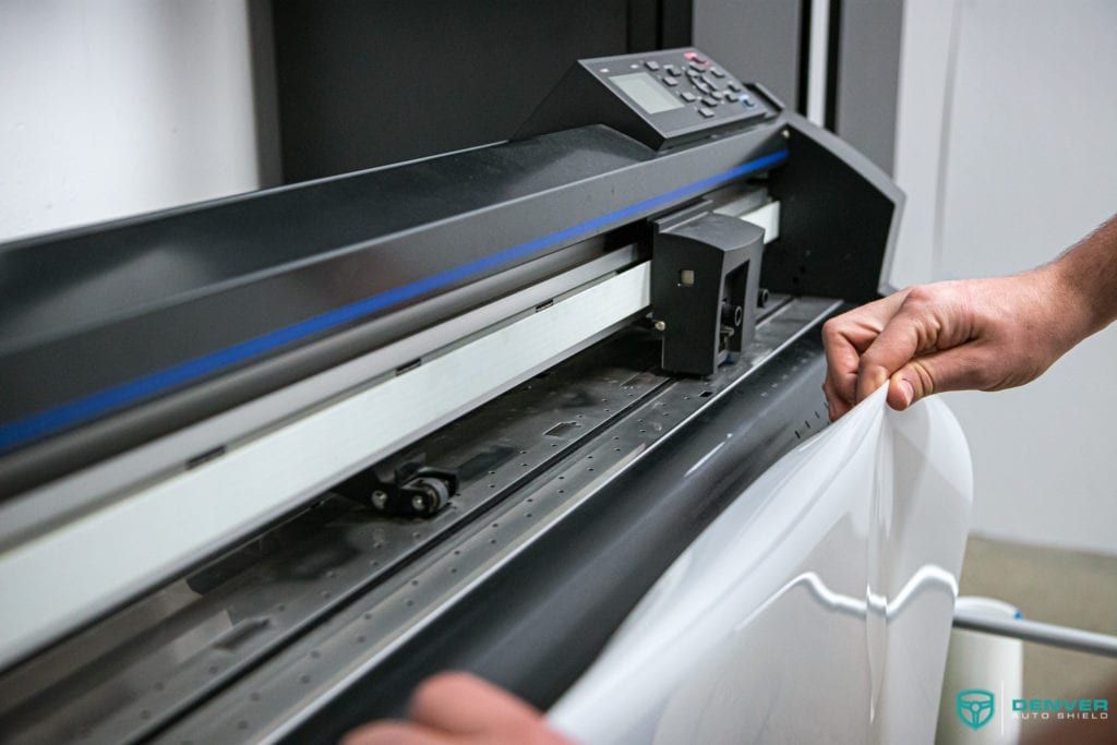 A person is using a cutting machine to cut a piece of paper.