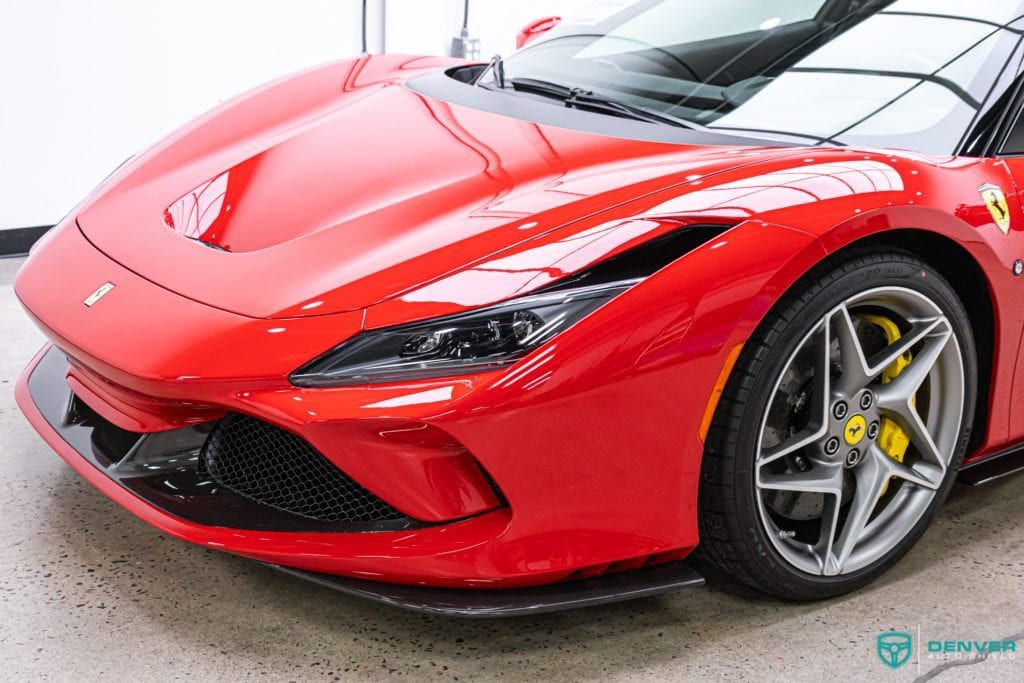 A red ferrari sports car is parked in a garage.