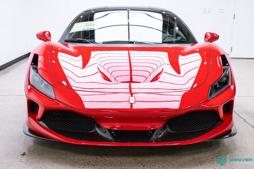A red sports car is parked in a garage.