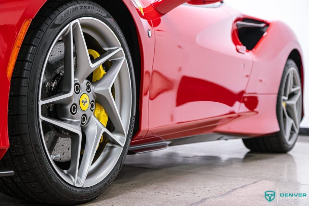 A red ferrari 488 gtb is parked on a concrete floor.