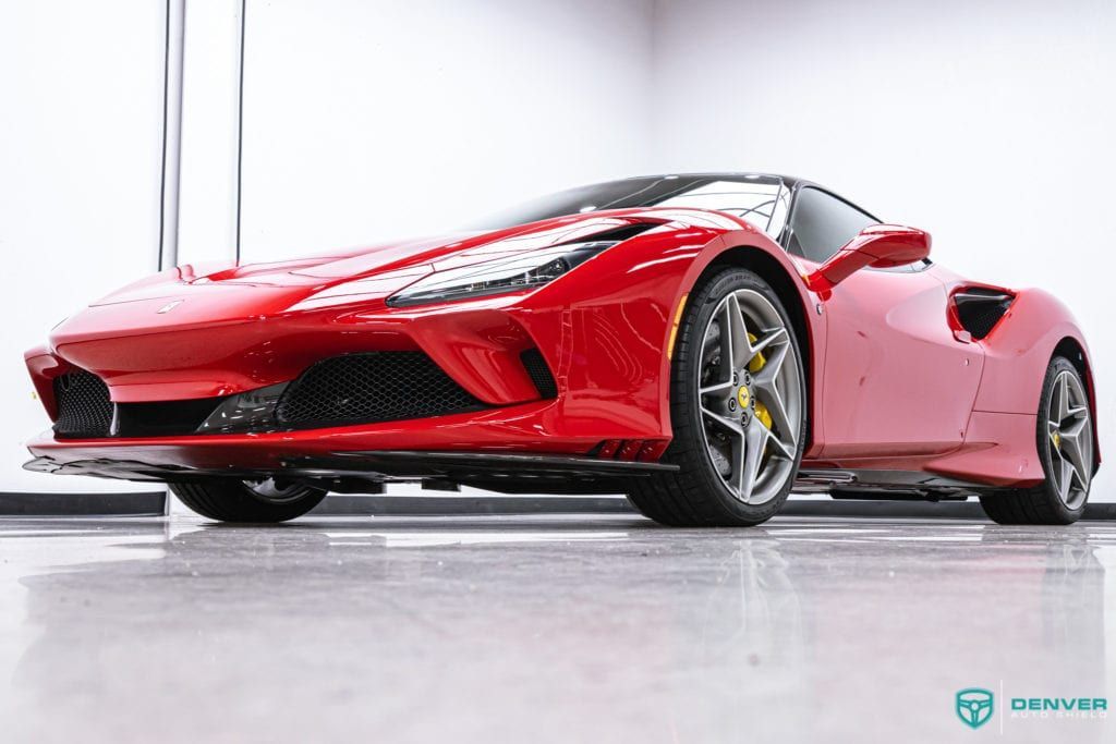 A red ferrari 488 spider is parked in a garage.