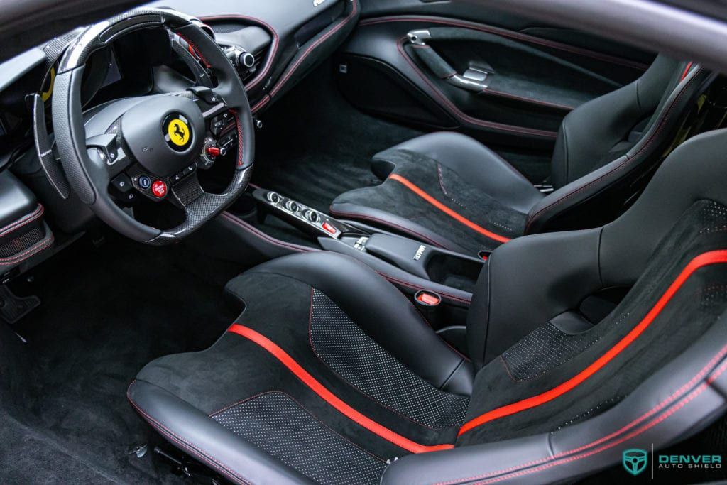 The interior of a ferrari sports car with black and red seats