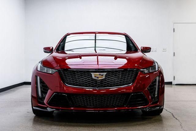Front view of a red Cadillac sedan in a white studio garage