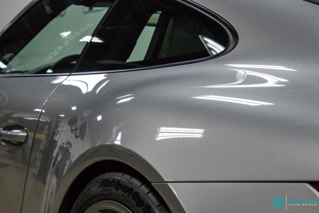 A close up of a silver car with a continental tire