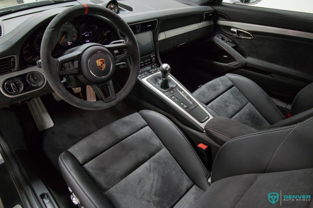 The interior of a porsche 911 gt3 with black leather seats and a steering wheel.