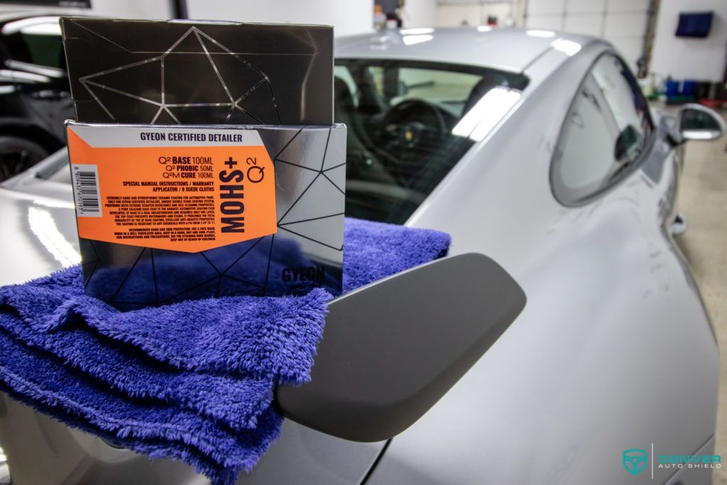 A towel is sitting on the side of a car next to a box.
