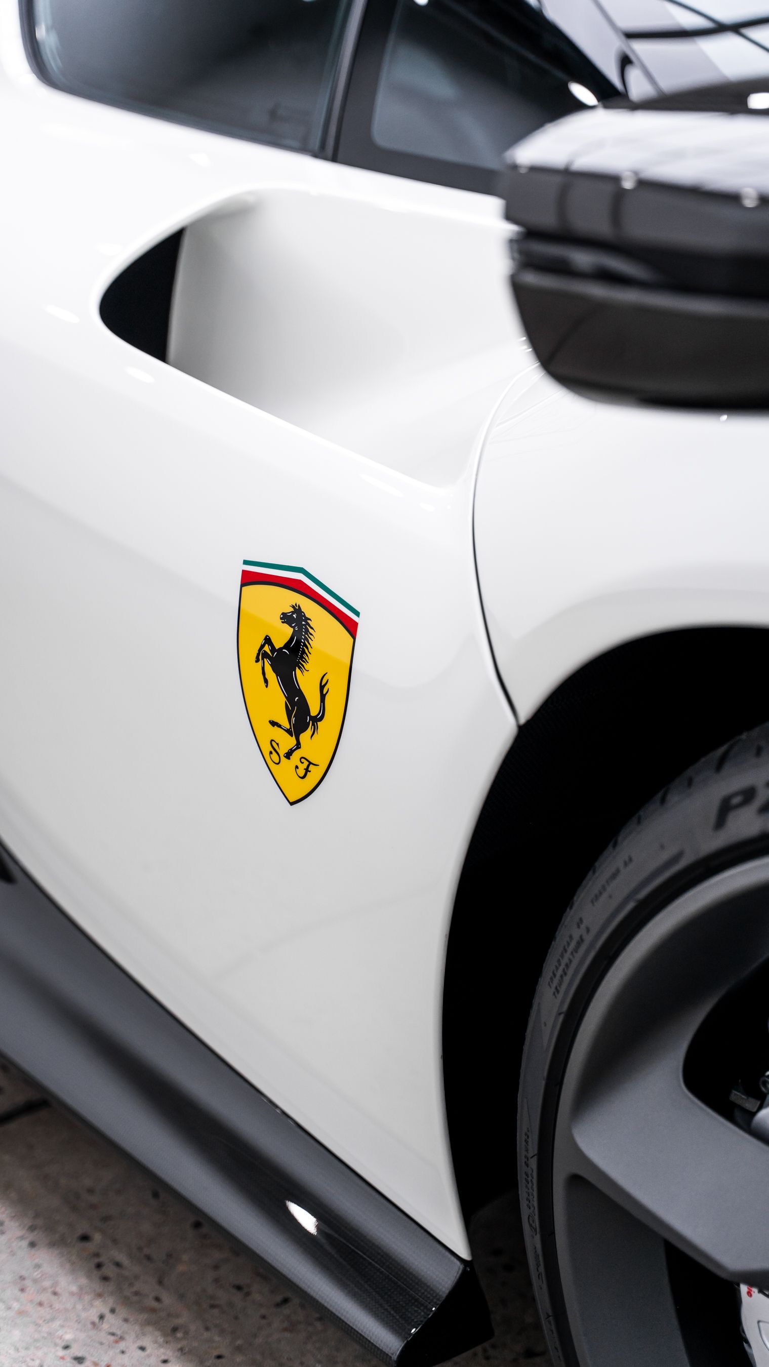 White Ferrari with a black shield logo, near the front tire.
