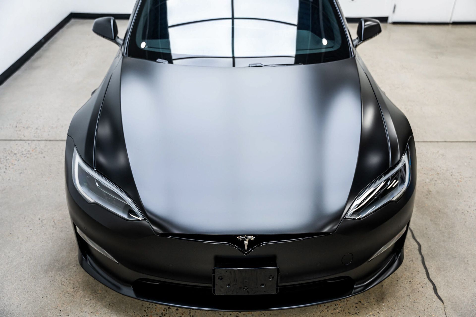 A black tesla model s is parked in a garage