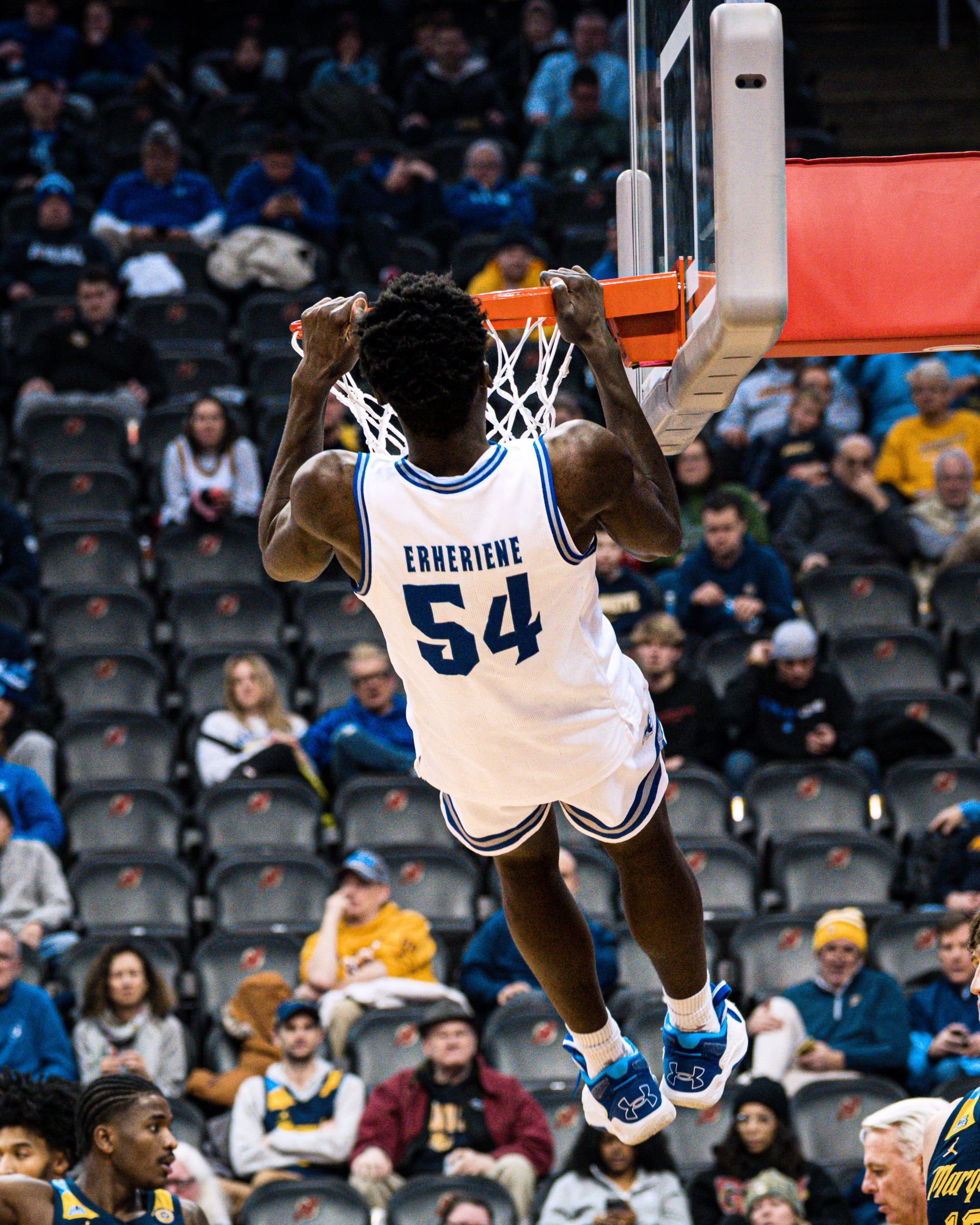 Memphis Grizzlies player #54 dunks during a basketball game, seen from behind near the hoop.