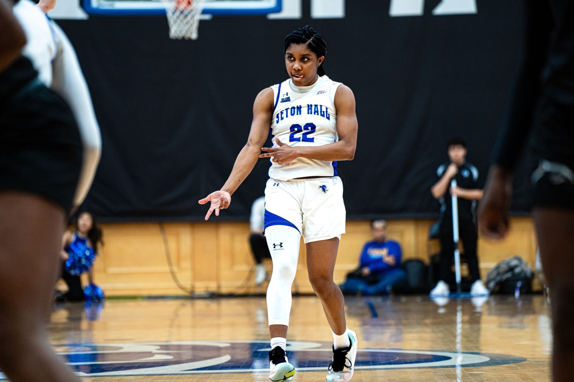 Basketball player in white uniform dribbling on a gym court during a game