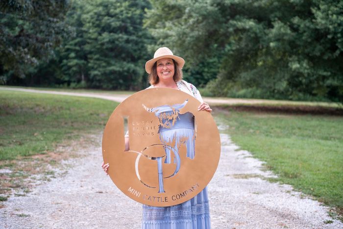 Pennie holding Lucky Pennie Farms Logo at farm.