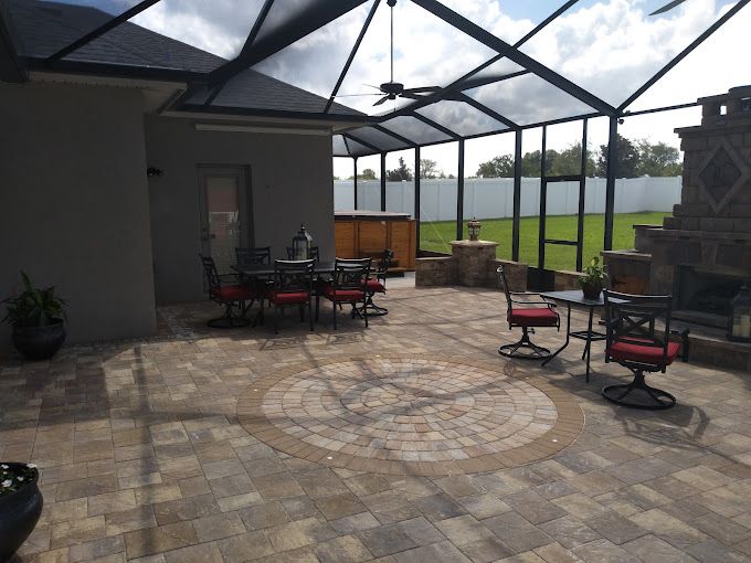 A screened in patio with tables and chairs and a fireplace