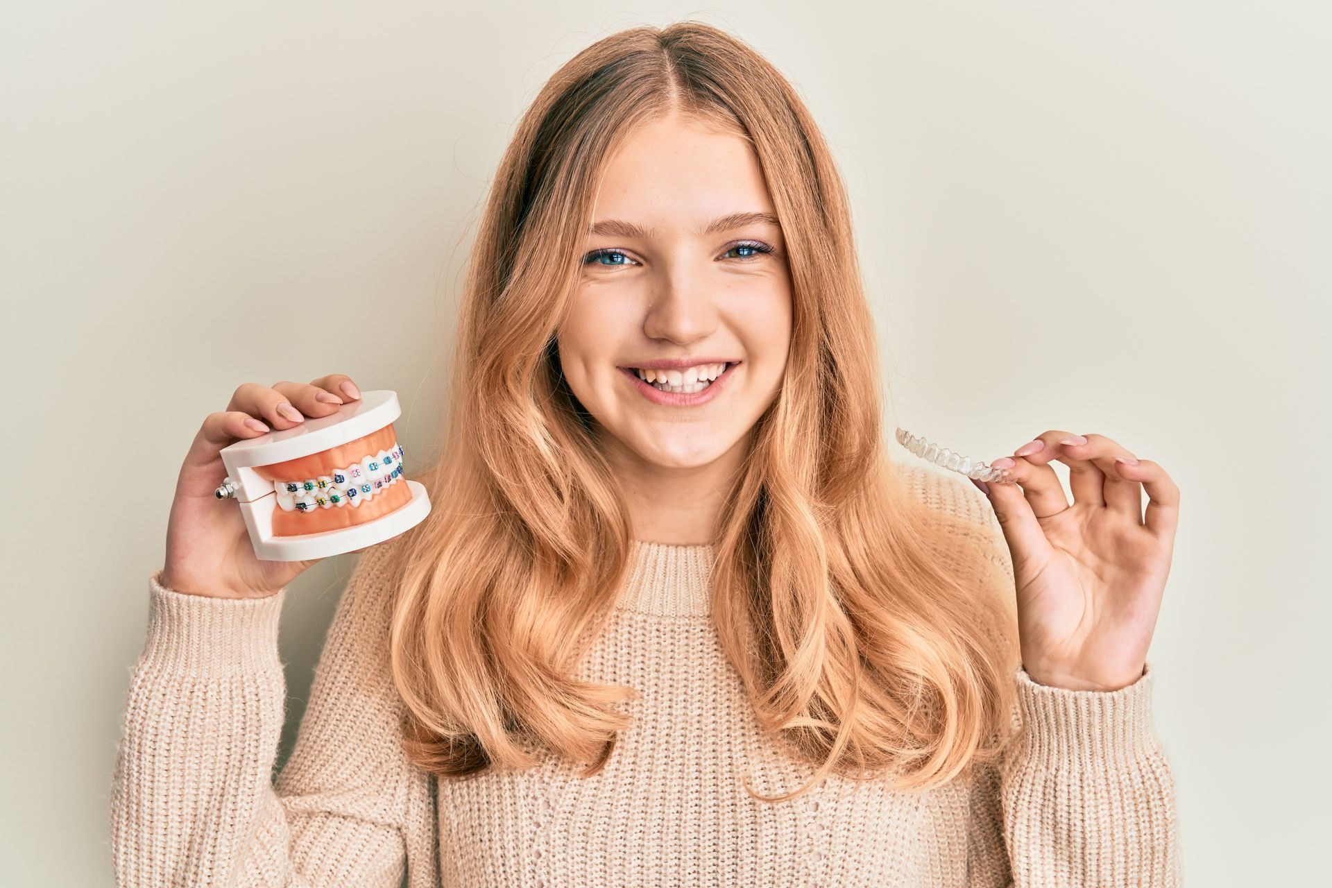 Happy teen girl discussing orthodontic care during routine pediatric health check ups.