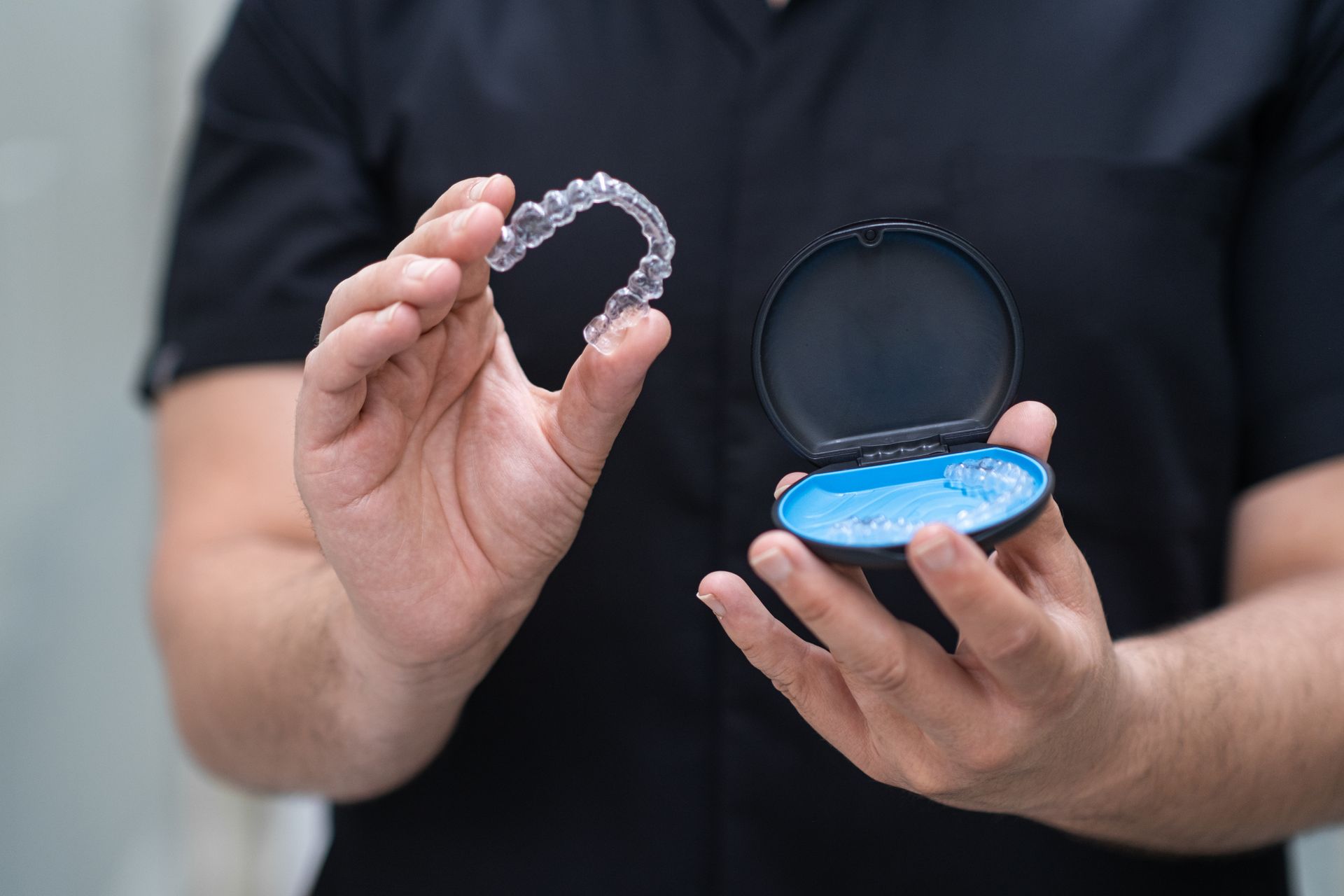 A dentist is taking out aligners from a case.