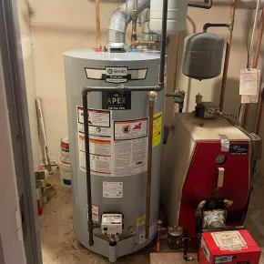 Apex Climate Control -  A blue water heater is next to a gray water heater