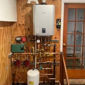 Apex Climate Control -  A room with a boiler and copper pipes on the wall.