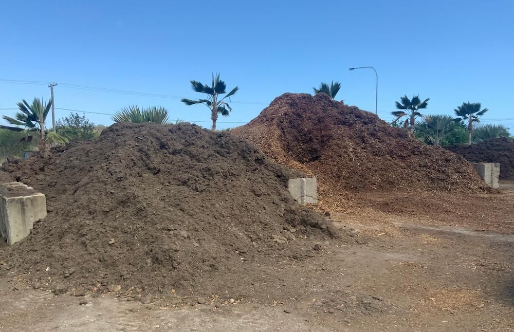 Two Piles Of Dirt Are Stacked On Top Of Each Other In A Dirt Field — Scott Kennedy's Landscape & Garden Supplies In Shaw, QLD