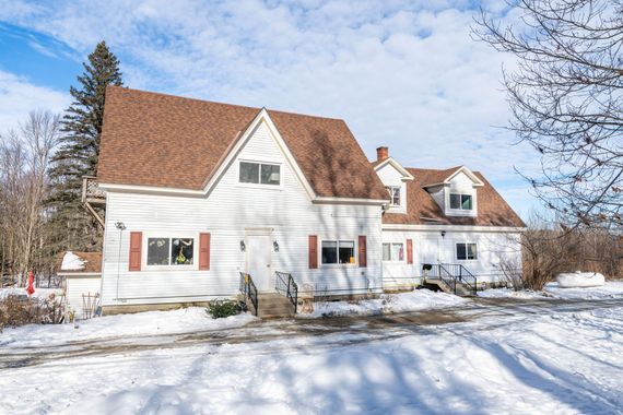 White two-story house rental property in Sugar Hill, NH by Loveless Family Properties