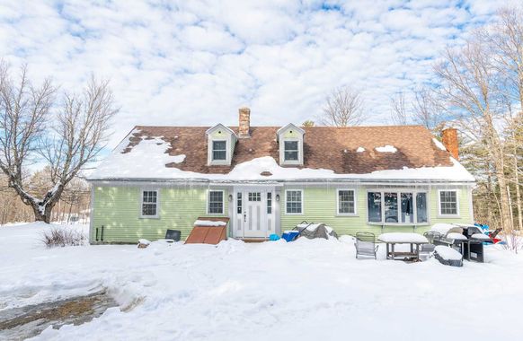 White two-story house rental property in Sugar Hill, NH by Loveless Family Properties