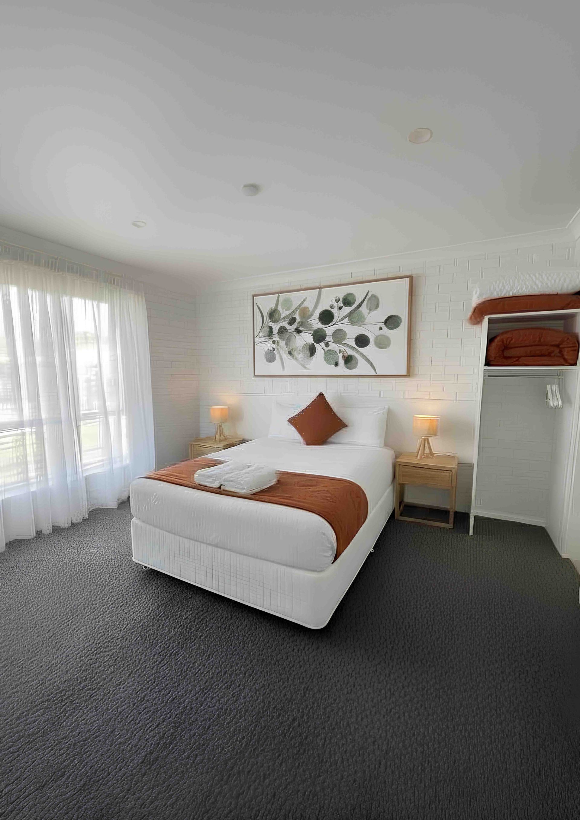 A motel room with two twin beds, a brick wall, and a bathroom.